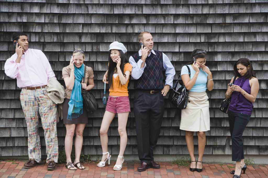 group of diverse young millennials on cell phones and mobile devices