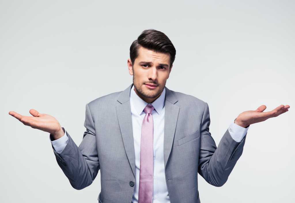 Man in gray suit holding hands up in frustration